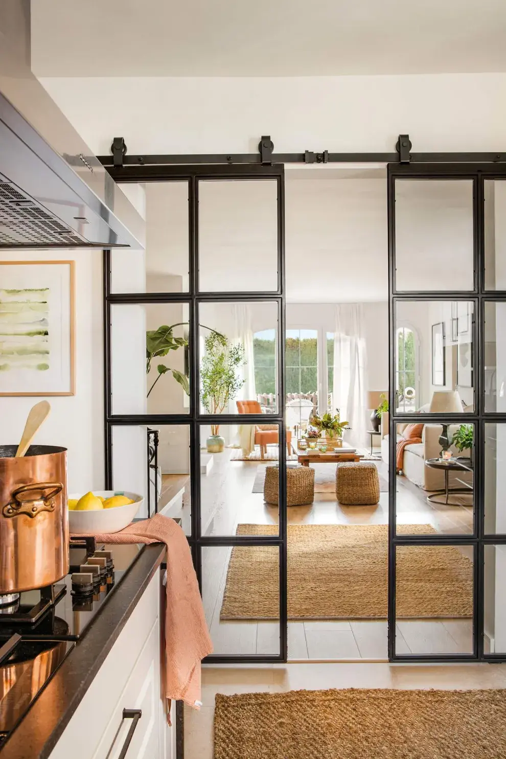 En cocinas integradas al living o comedor, permiten mantener una planta abierta durante el día y cerrar el ambiente cuando se cocina, evitando que los olores o el ruido se propaguen.