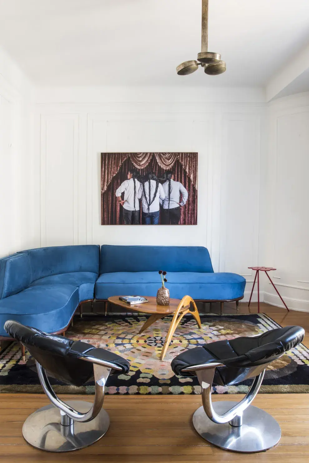 En el departamento @sabu.buenosaires, sillón esquinero de la firma Englander & Bonta retapizado en pana azul, mesa de centro, alfombra creada por Aníbal Carreño (todo de Mid Century, de Santiago del Campo). Lámpara colgante (El Sótano Vintage).