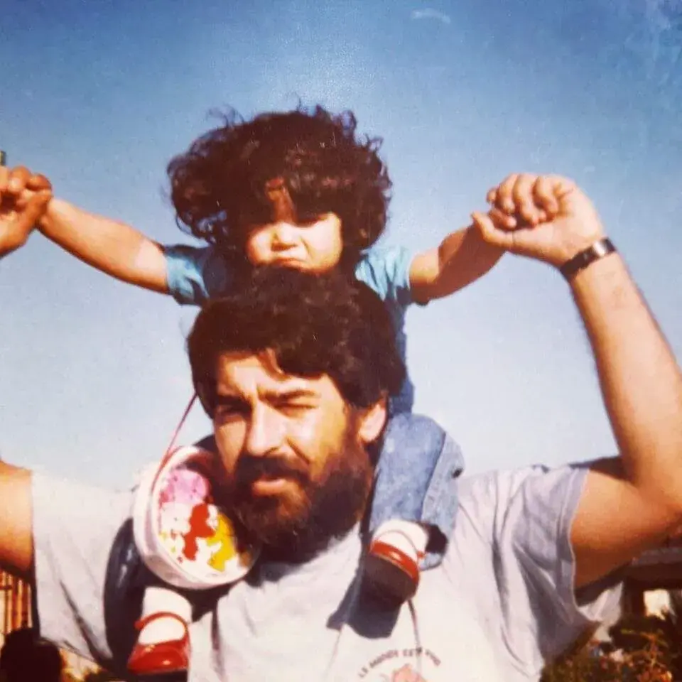 Alan, en su infancia, cargado por su papá.