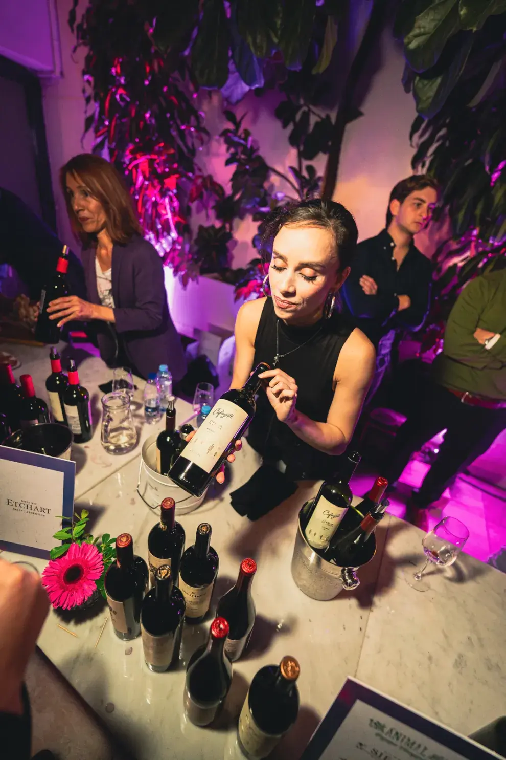 Una mujer ofreciendo un vino malbec