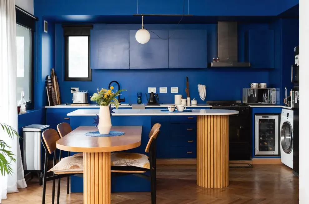 La mesa hecha por un amigo carpintero borra los límites entre la cocina y el comedor.