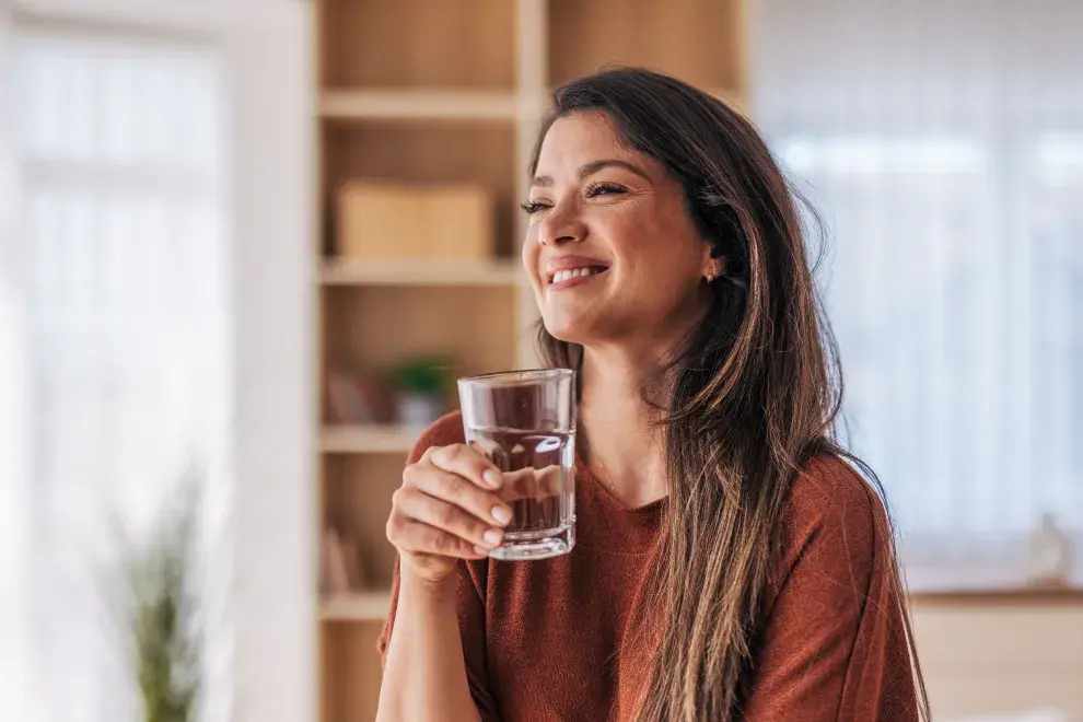Foto de mujer con vaso de agua.