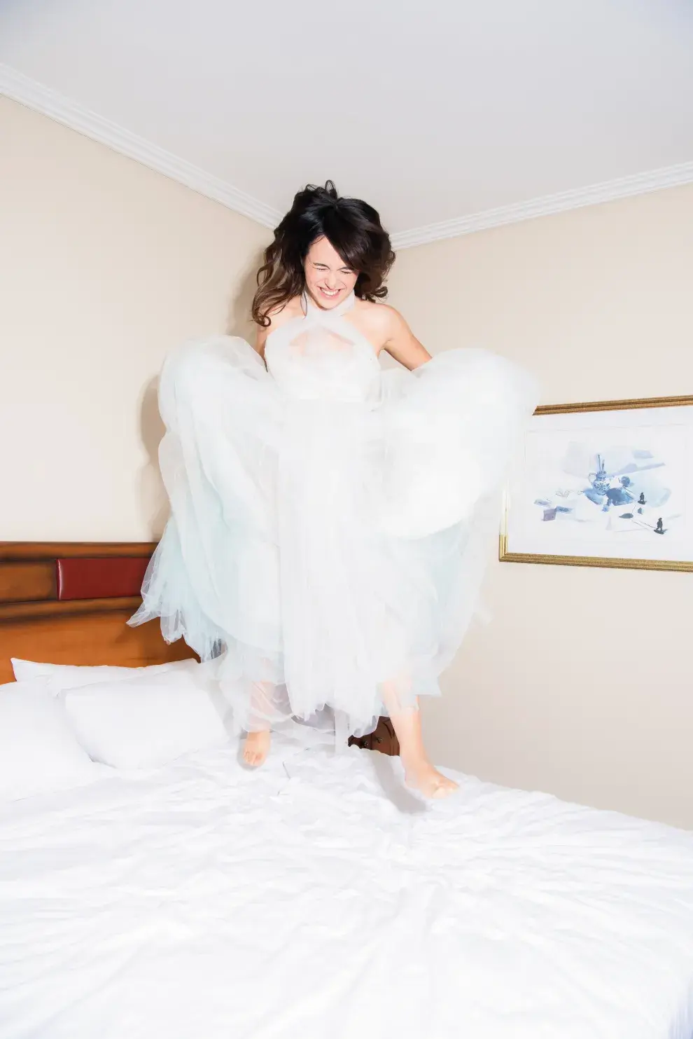 Evitta Luna saltando en la cama vestida de novia