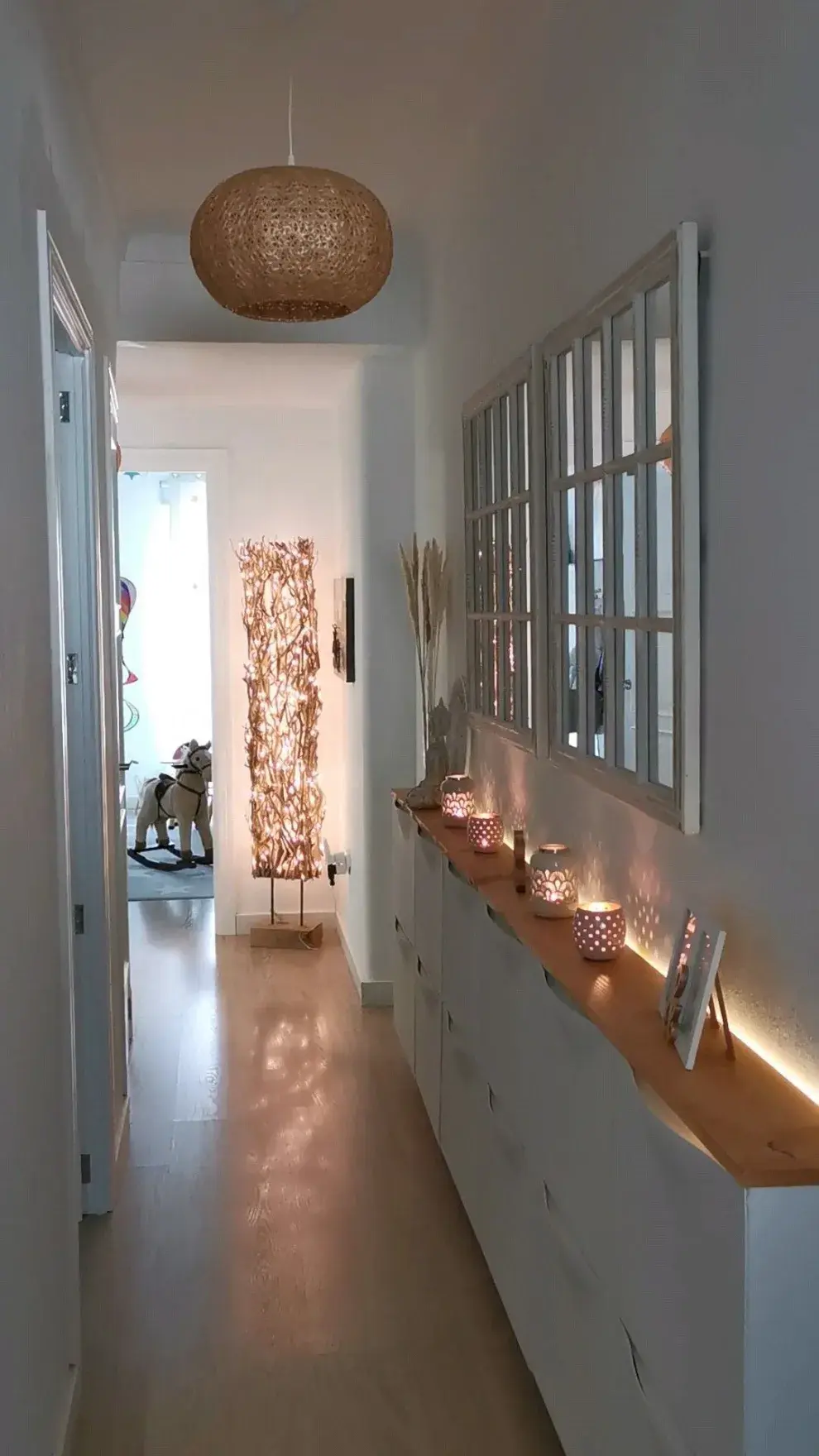 Una buena iluminación puede hacer que un pasillo oscuro se vuelva cálido y atractivo. Combiná luces de techo con apliques de pared o incluso tiras LED para generar profundidad.