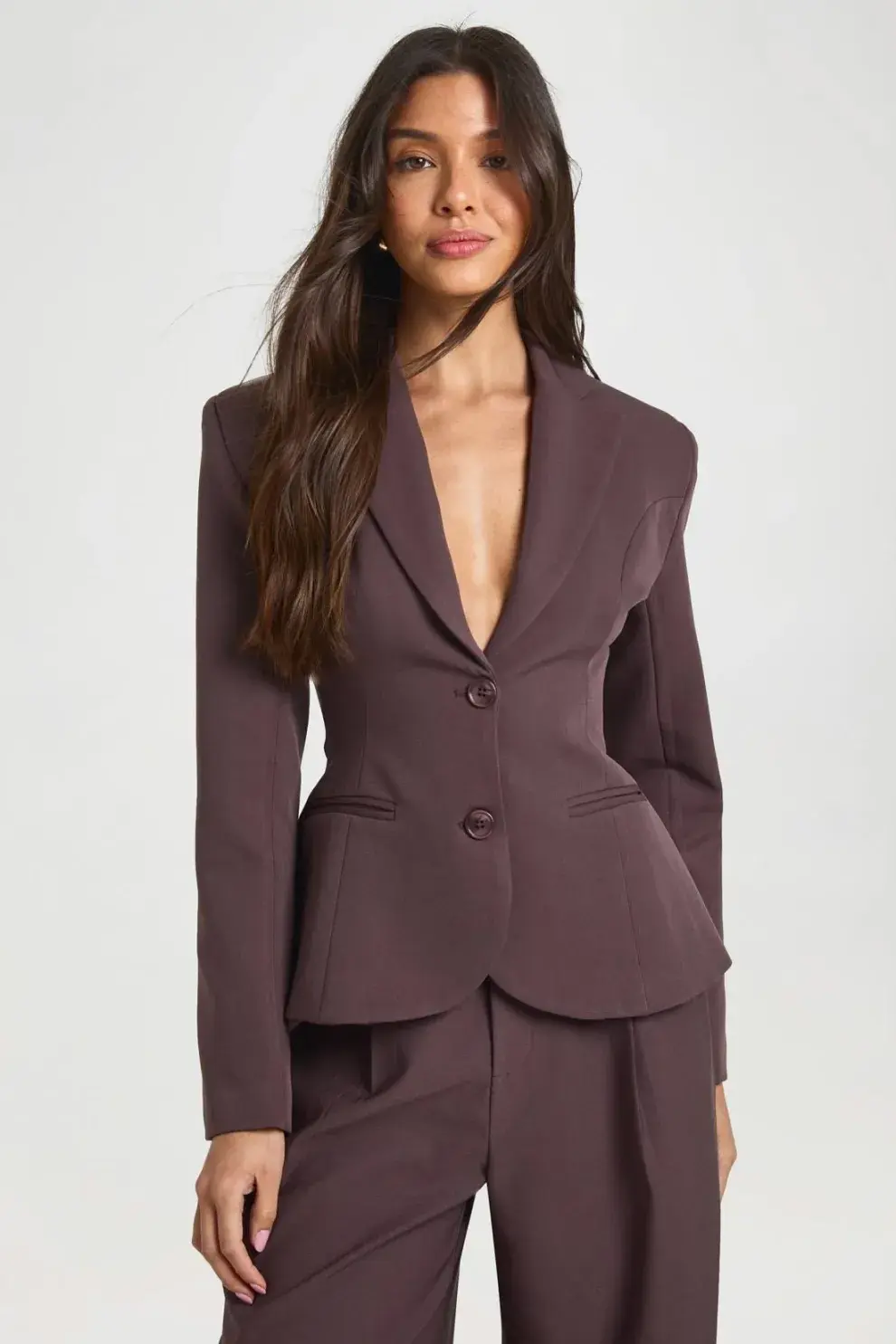 Este modelo tiene historia. Es heredero directo de la mítica “Bar jacket” de Christian Dior, una chaqueta que definió el New Look en 1947 con su silueta de reloj de arena.