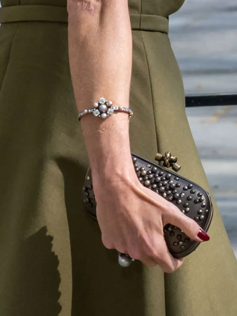 El conjunto se completó con pendientes, pulsera y anillo a juego, además de salones en tono gris y un clutch coordinado, logrando una paleta armónica entre verdes y neutros que refuerza su elegancia sin excesos.