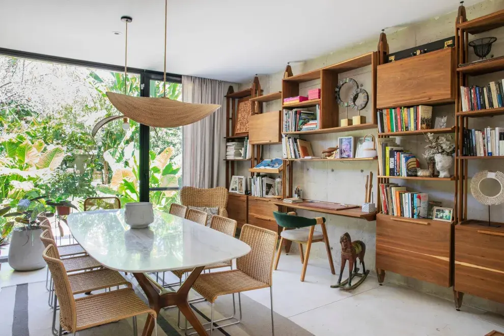 Mueble de incienso y roble, mesa con tapa de mármol, sillas apilables ‘Agnoli’ y luminarias colgantes tejidas (Estudio Bibiana Valeiras).