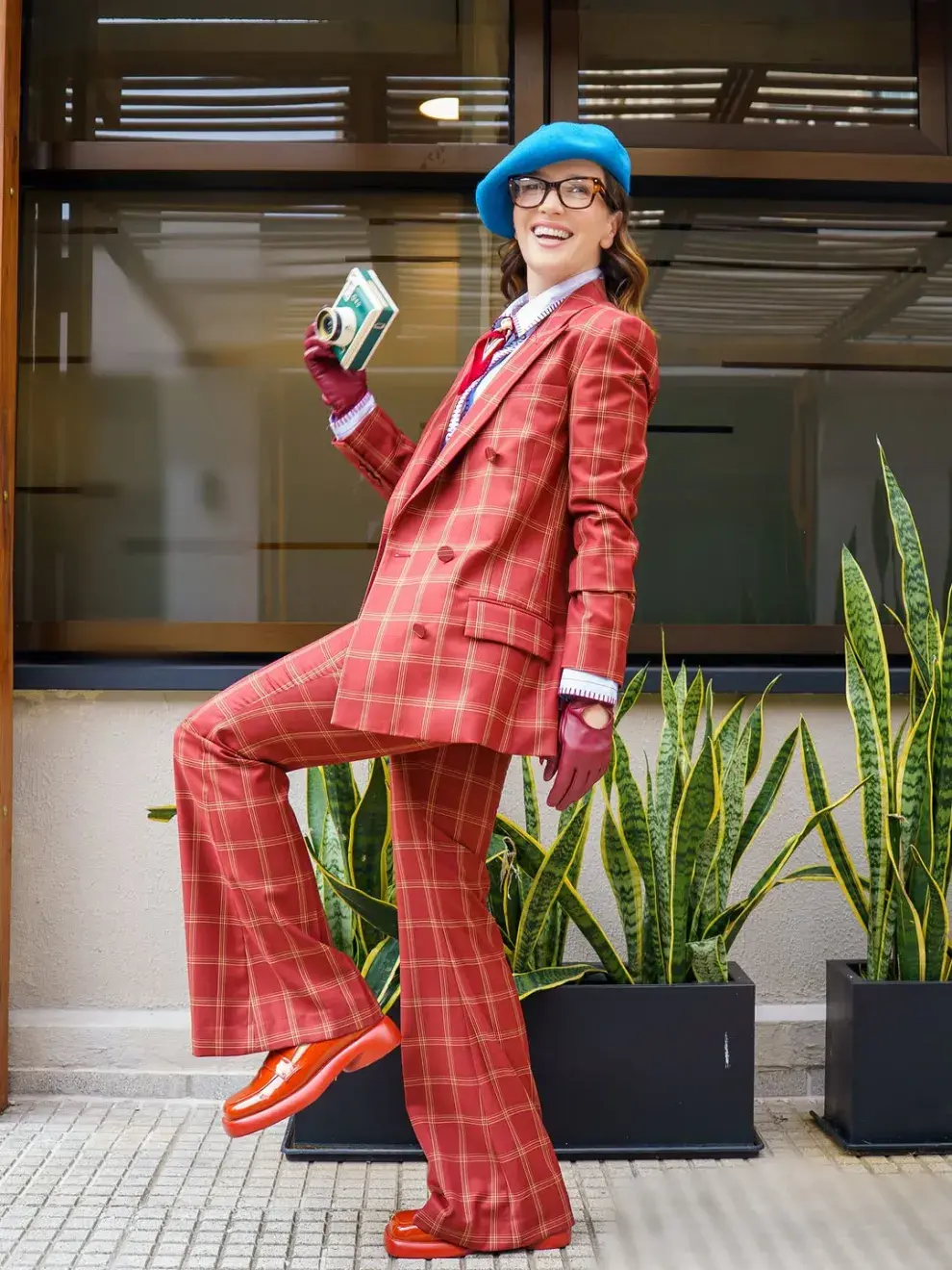 El look giró en torno a un conjunto de sastrería de cuadros rojos compuesto por blazer y pantalón de corte clásico.