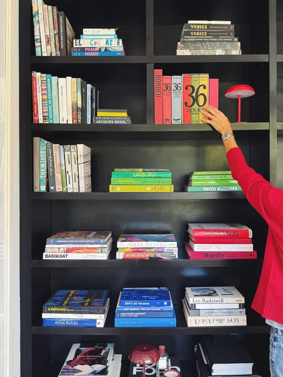 En lugar de llenar cada estante, Awada apuesta por una composición equilibrada donde conviven libros, objetos deco, piezas artesanales, velas y flores naturales.