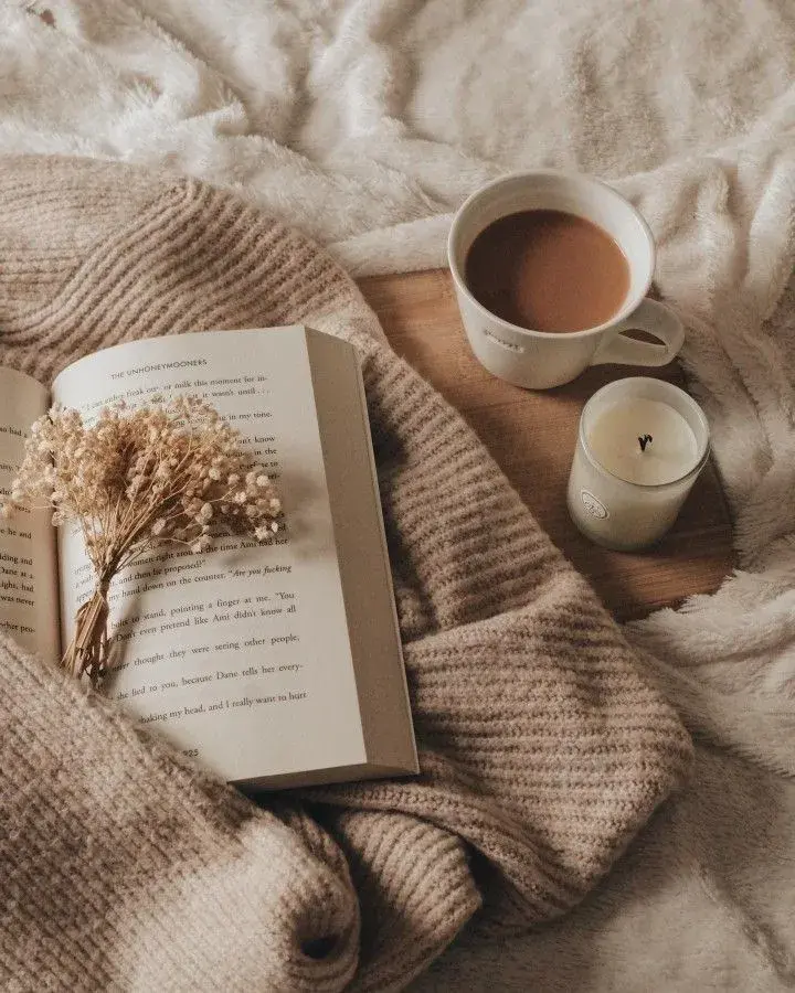 Foto de libro, manta y café.