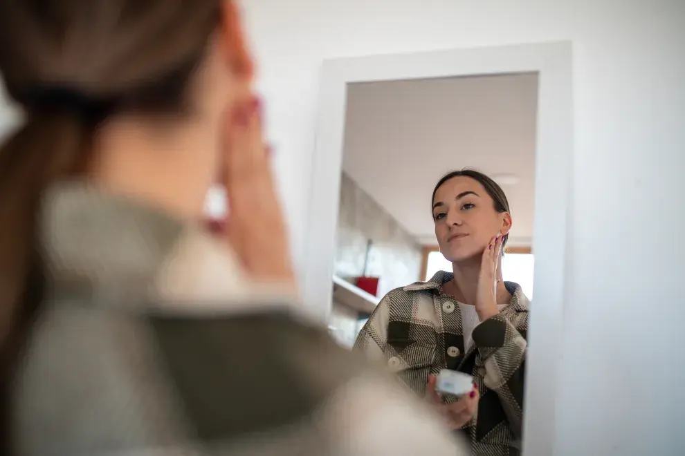 Foto de mujer limpiando su rostro.