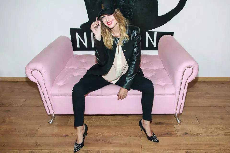 Geraldine Neumann con un look muy canchero: camisa, leggins, chaqueta de cuero y stilettos. La gorra...estaría de más