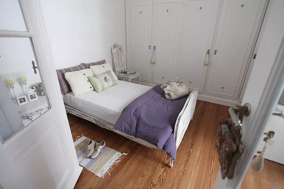 El dormitorio tiene doble acceso: desde el living y el pasillo. La cama, herencia de su abuelo, se restauró y patinó al igual que la mesa de luz que compró por Internet. Al otro lado, silla que su novio rescató de la basura y ella recicló, buscando mantener la pintura decapada por el tiempo