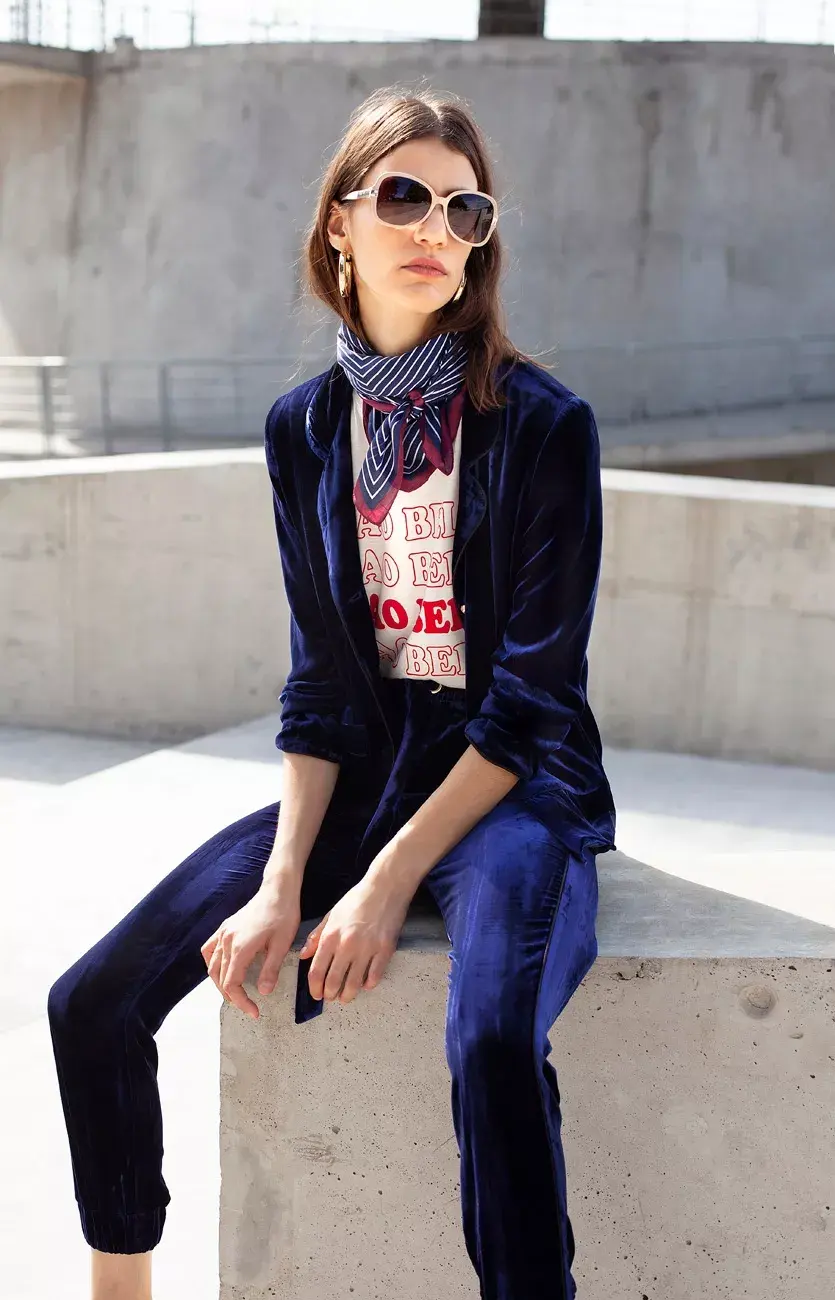 Traje velvet de saco y pantalón (Ginebra, $6800 y $5200), remera (Yagmour, $499), anteojos (Fleur, $1950), argollas (Luna Garzón, $1200), pañuelo (Estancias, $440)
