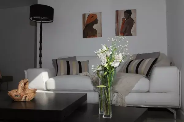 En el Living, sillón y un mantón en lana de llama ($875, Elementos Argentinos). Mesa baja Twister ($4072, Fontenla) y bandeja de teca tallada a mano ($1050, Cuatro Elementos). Los óleos sobre madera ($2100 c/u, Nana mía)