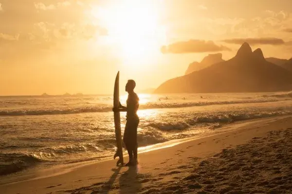 Tiene esa cosa salvaje que le infunde el océano y te hipnotiza con la mirada fija en el horizonte, hablando con otros, tan perfectos como él, sobre la mejor manera de treparse a una ola
