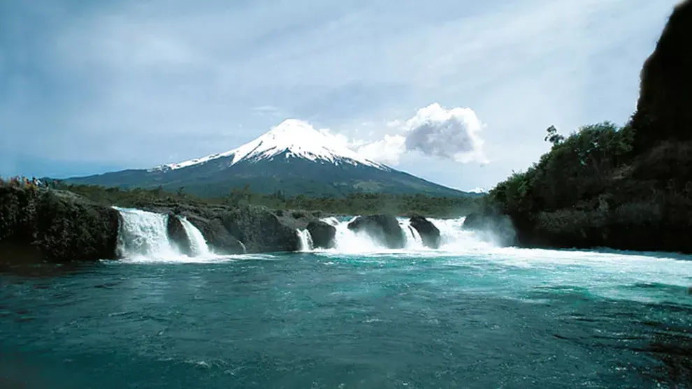 Los saltos de Petrohué y la silueta del volcán Osorno, en el parque Pérez Rosales