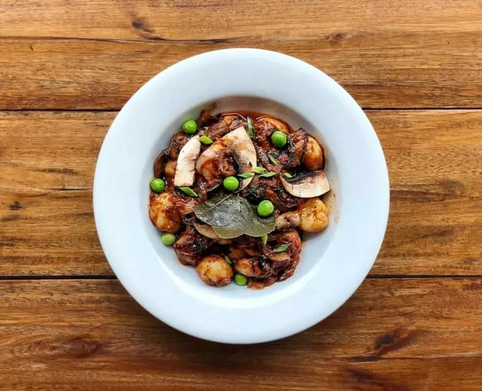 Ñoquis de papa con verdeo, portobellos, pesto de tomates y hojas de alcaparra. Foto: Fifí Almacén