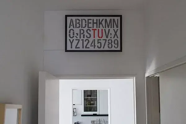 El cuadrito con letras lo hizo para tapar un agujero que había en la pared, utilizó un stencil que se consigue en cualquier libreria