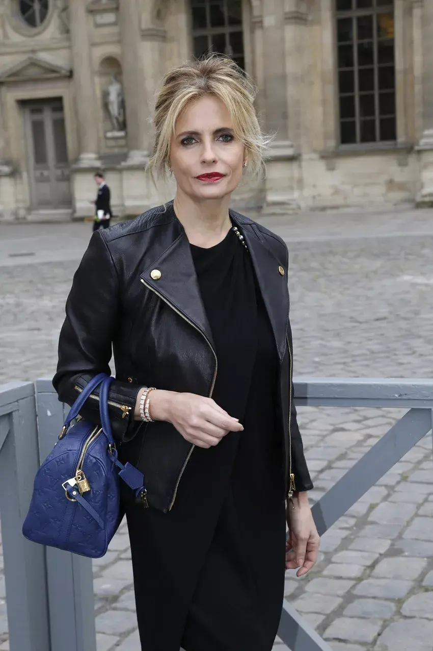 Isabella Ferrari, la actriz y modelo italiana, le da unos toques de color a su atuendo con la cartera en azul eléctrico de Louis Vouitton y los labios en rojo