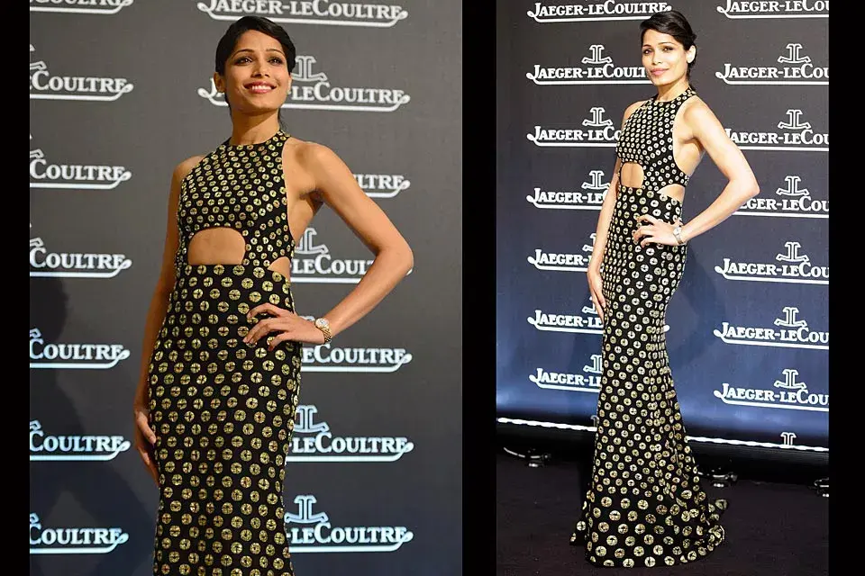 Con un estilo bien moderno, Freida Pinto eligió un vestido en negro con lunares dorados, escote cerrado y recortes en la cintura de Alexander McQueen