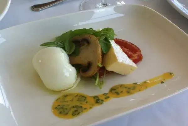 Huevo poche con brie, rúcula, hongos y tomates confitados