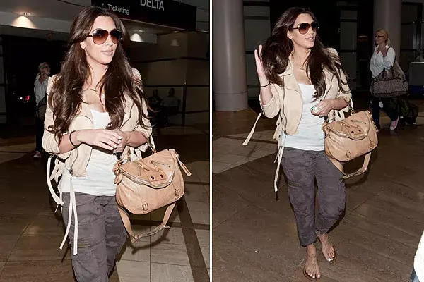 Para viajar cómoda, Kim Kardashian elige pantalones cargo con estampa camuflada y chaqueta de cuero corta en color camel