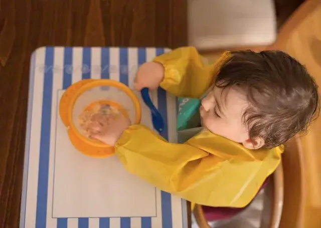 A los seis meses ya puede  usar la cuchara y empezar  aprender cómo es eso de comer solito. Foto Corbis.