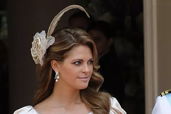 Con el pelo suelto con algunas ondas, la princesa Madeleine de Suecia eligió un semirrecogido con un aplique con una flor de organza y una pluma