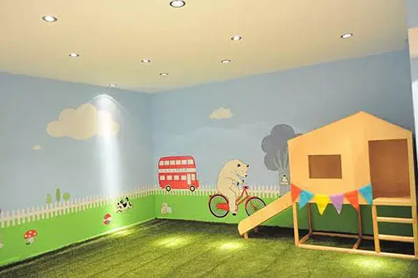 Uno de los espacios de juego, con una casita de madera