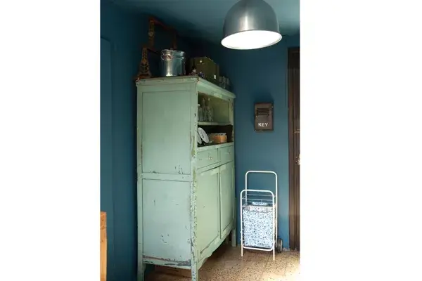 Junto al mueble de campo antiguo está el changuito de compras y una bolsa plegable eco.