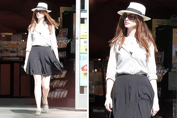 Anne Hathaway eligió un estilo simple pero glam en el que los accesorios son todo: una camisa y una falda plisada se realzan con mocasines con tachas, sombrero Panamá y mega anteojos