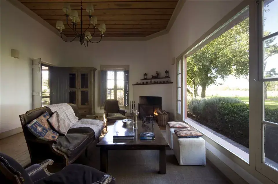El living del hotel, con un gran ventanal con vista al campo