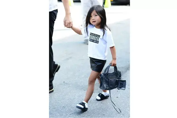 Aila con un outfit muy canchero en el desfile de su tío: remera, pollera de cuero y mini cartera