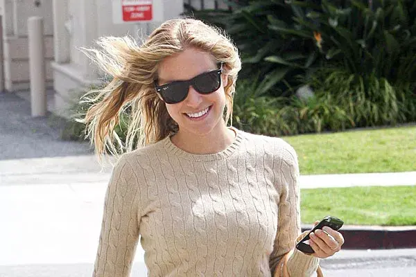 Kristin Cavallari camina muy sonriente por la calle sin notar que su pelo apunta hacia cualquier lado