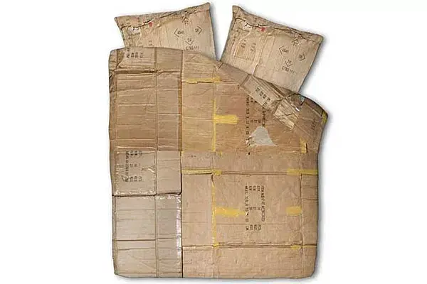 Acolchado que simula ser de cartón; las inscripciones y la cinta adhesiva lo hacen muy real