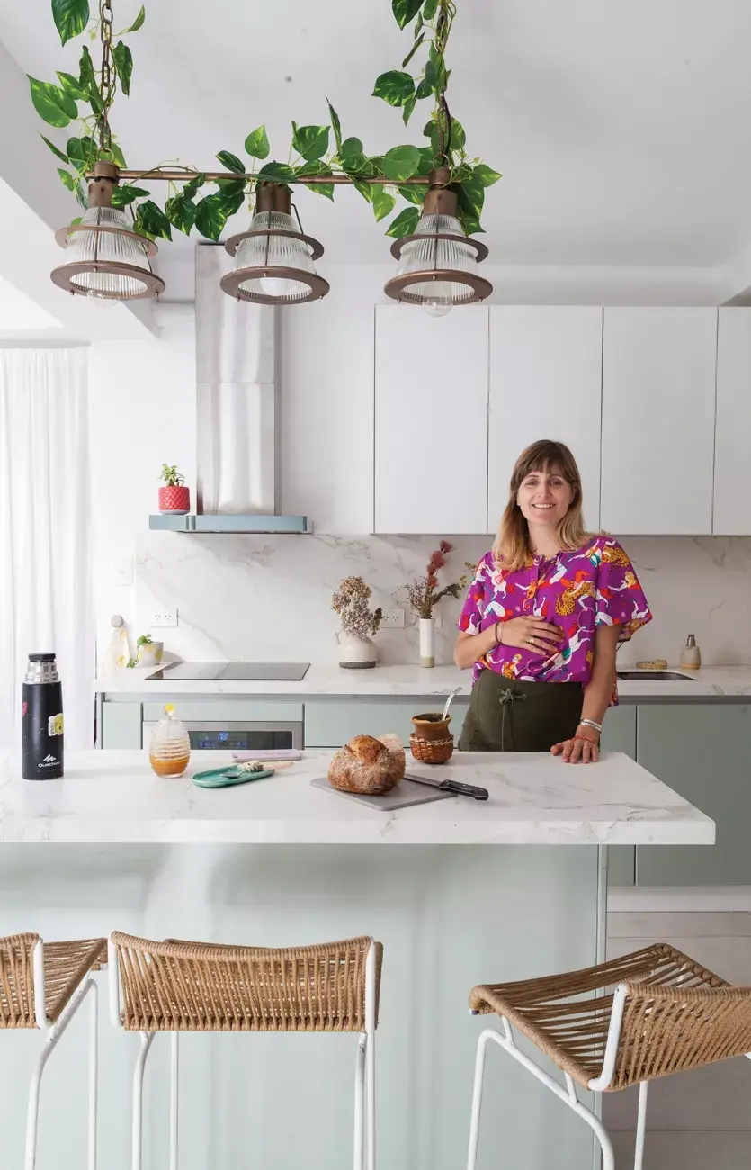 Todo pasa en la isla, que tiene mesada Dekton mate. El tono de verde era una obsesión de Lulu: está por toda la casa y en la planta que se enrosca en la lámpara (Compañía Nativa).