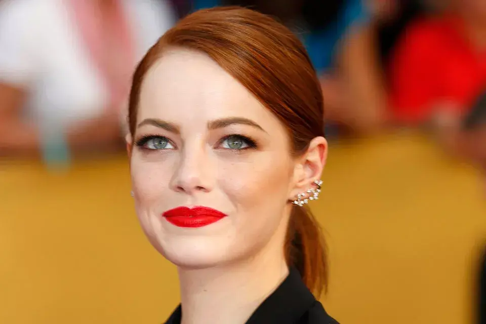 Emma Stone optó por un recogido con raya al costado para resaltar su earcuff de brillantes. Completó el estilismo con labios en color rojo y los ojos bien marcados