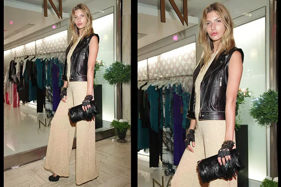 Rocker chic: Chloé Bello combinó un enterito de corte Oxford con brillo con chaleco de cuero, estiletos, guantes y sobre con plumas para la inauguración de Naima