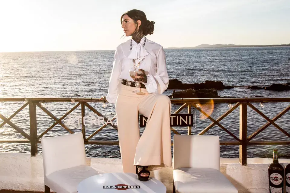 Cande Tinelli, bien clásica con pantalón palazzo, camisa con jabot y un cinturón criollo tipo rastra en Terraza Martini