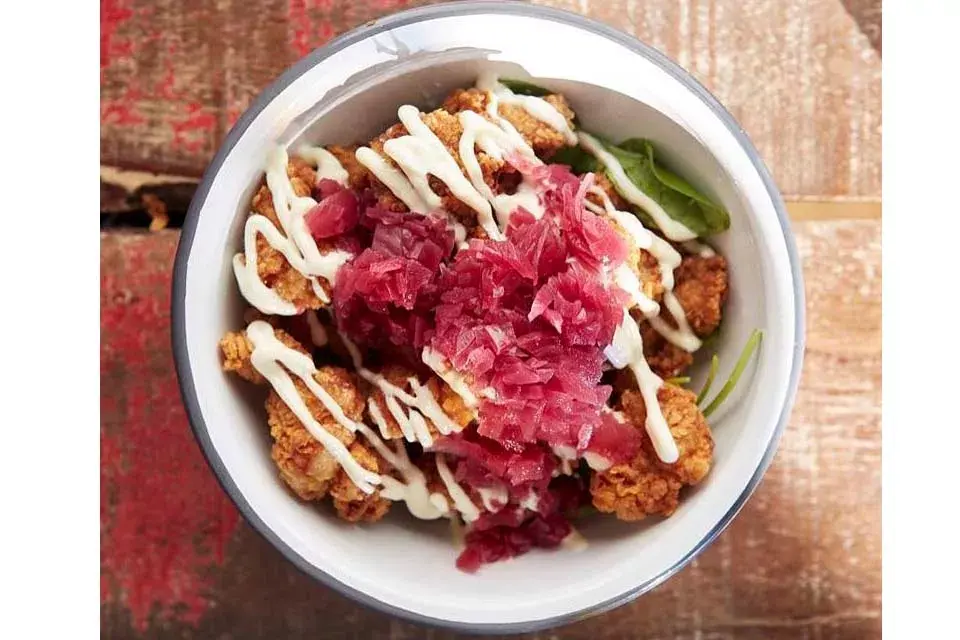 Mollejas fritas, se sirven rúcula, alioli, limón y cebolla pickle