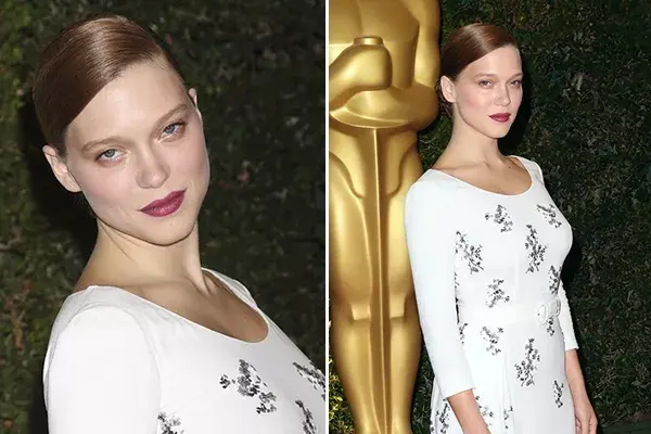 Lea Seydoux con un moño bien tirante con raya al costado para acompañar su  long white dress
