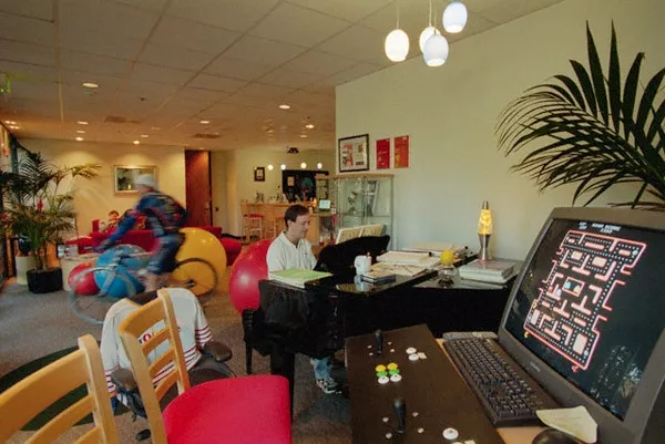 Un empleado de Google tocando el piano. Detrás, otro anda en bici