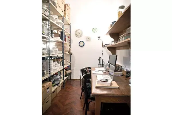 Como escritorio, una mesa de pinotea bien larga y una estantería de metal que sirve como archivo múltiple.