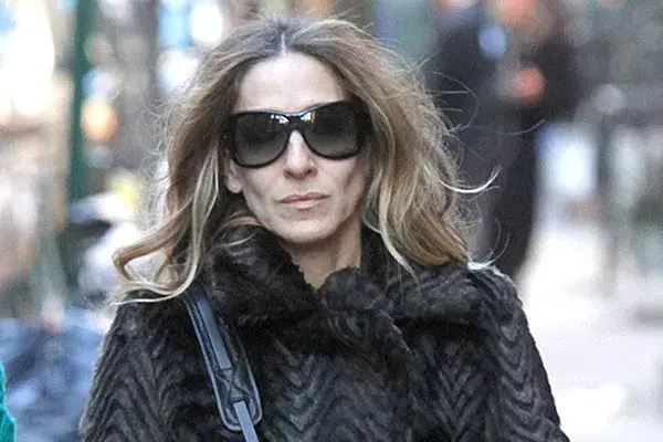 Satah Jessica Parker camina por la calle un peinado con brushing y raya al medio (¡Y mucho frizz!)