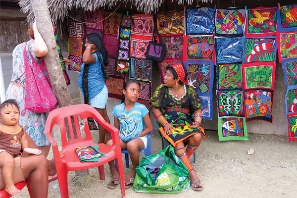 Las mujeres de la comunidad guna trabajan el mola y arman unos tapices de telas cosidas que representan figuras relacionadas con la naturaleza. Las usan como vestimenta junto con vinchas llamadas musue y pulseras en las piernas (wini)