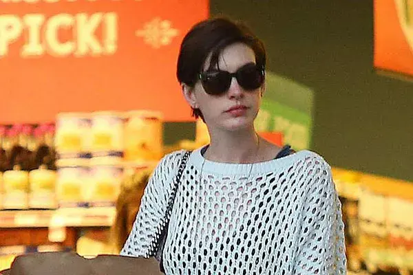 Con el pelo corto y peinado hacia un costado, Anne Hathaway hace las compras en el súper