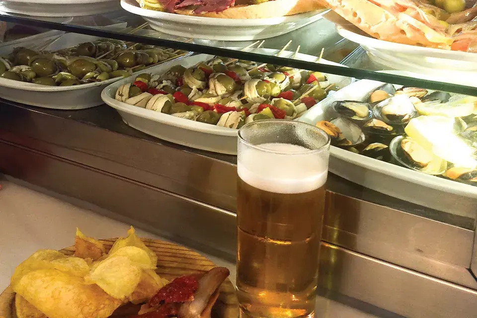 Es un lugar tradicional madrileño, de esos que están abarrotados de botellas de vino de piso a techo y recipientes gigantes llenos de pulpo, mejillones o aceitunas maceradas de distintas variantes