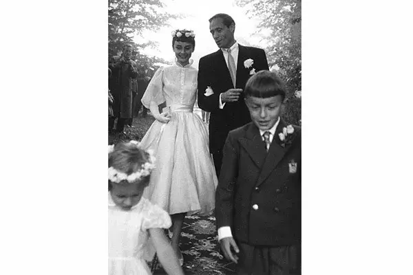 Muy elegante se casó Audrey Hepburn con el actor Mel Ferrer en 1954. Usó un vestido que realza su diminuta cintura, con mangas de chifón y falda plisada. Las flores fueron el toque justo para ella, el novio y el cortejo