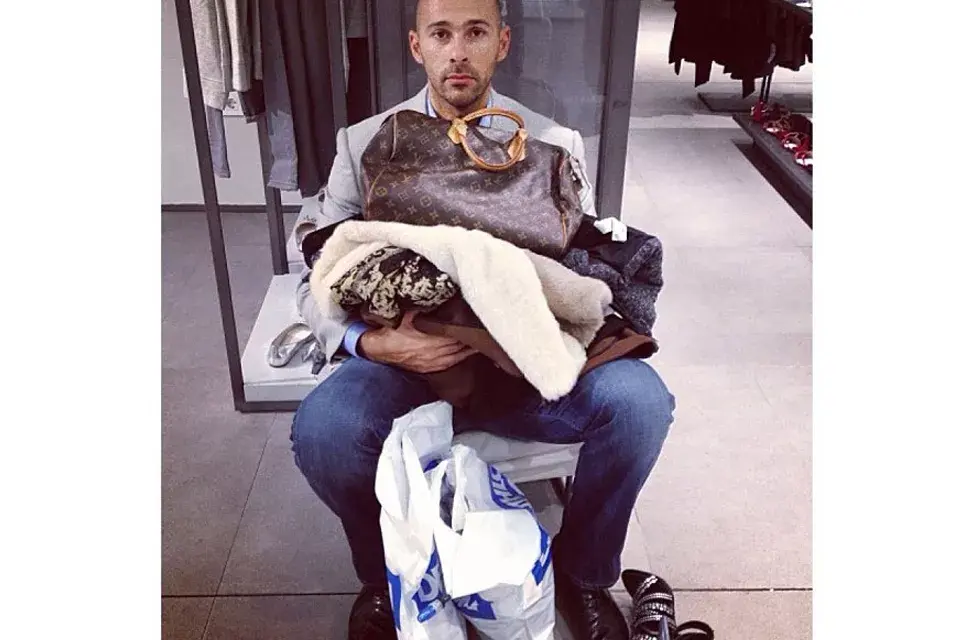 ¿Algo más? Con mucha paciencia, este hombre se esconde tras la pila de compras de su mujer